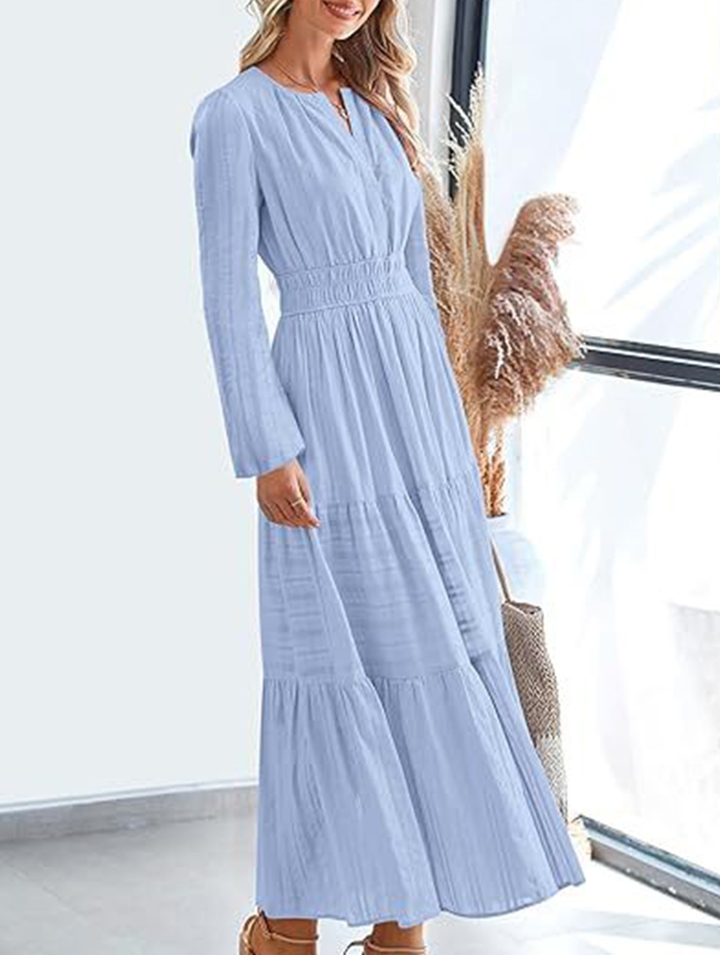 Light blue V-neck pleated waist tiered long-sleeved dress with a flowy silhouette, featuring a stylish and elegant design.