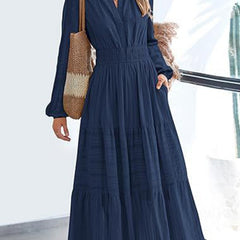 Navy V-neck pleated waist tiered long-sleeved dress with flowy layers and elegant design, perfect for stylish occasions.