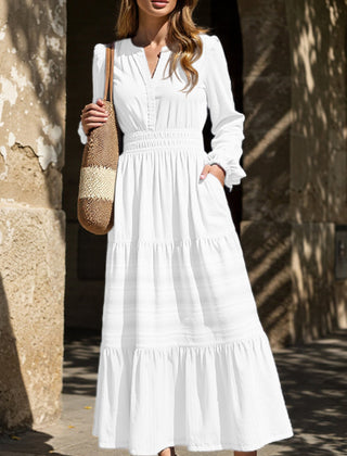 White V-neck pleated waist tiered long-sleeved dress with flowing fabric and elegant design, perfect for stylish occasions.