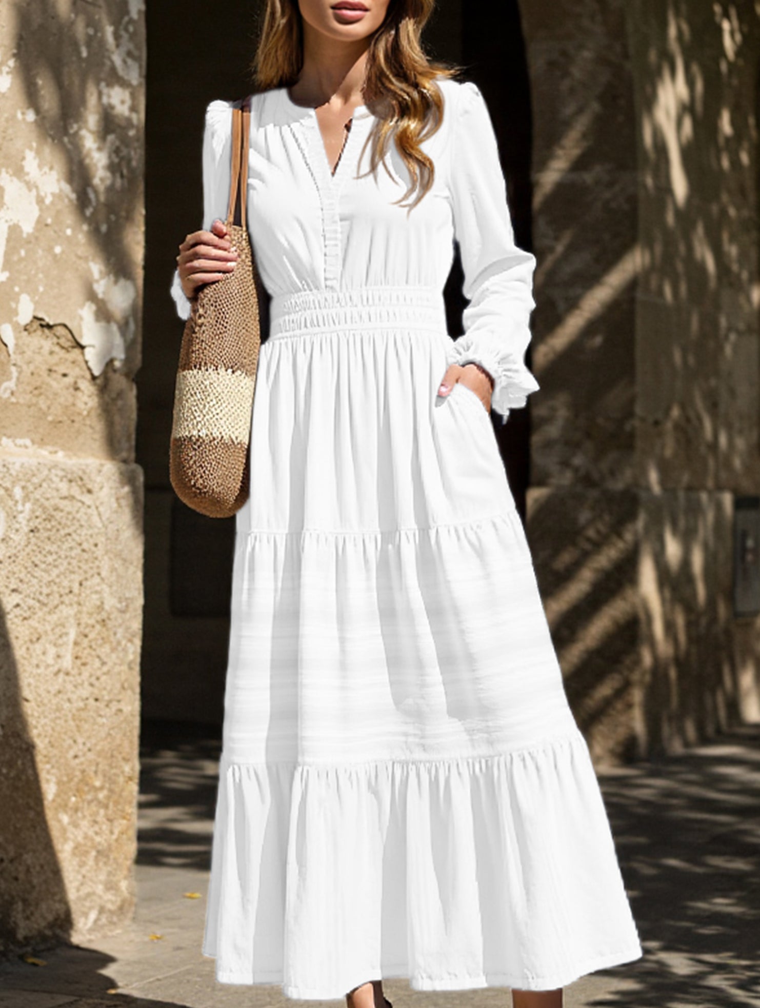 White V-neck pleated waist tiered long-sleeved dress with flowing fabric and elegant design, perfect for stylish occasions.