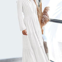 White V-neck pleated waist tiered long-sleeved dress with flowing fabric and a fitted waist, perfect for elegant occasions.