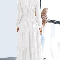 White V-neck pleated waist tiered long-sleeved dress with a flowing silhouette and elegant design.