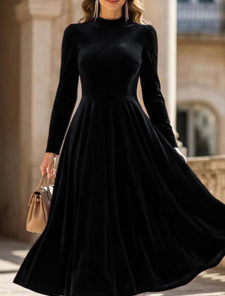 Black velvet long-sleeved round neck dress by Tammy Bradley, showcasing a sleek, fitted design with a smooth fabric finish.