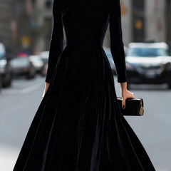 Black velvet round neck long-sleeved dress by Tammy Bradley, featuring a elegant fit and smooth fabric, displayed on a hanger.