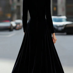 Black velvet round neck long-sleeved dress by Tammy Bradley, shown on a hanger against a plain background.
