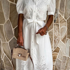 White pastoral style openwork embroidered dress featuring intricate embroidery and a flowing design, perfect for casual or formal wear.