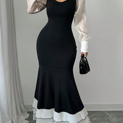 Black colorblock long sleeve mermaid dress with fitted silhouette, stylish design, and elegant neckline.