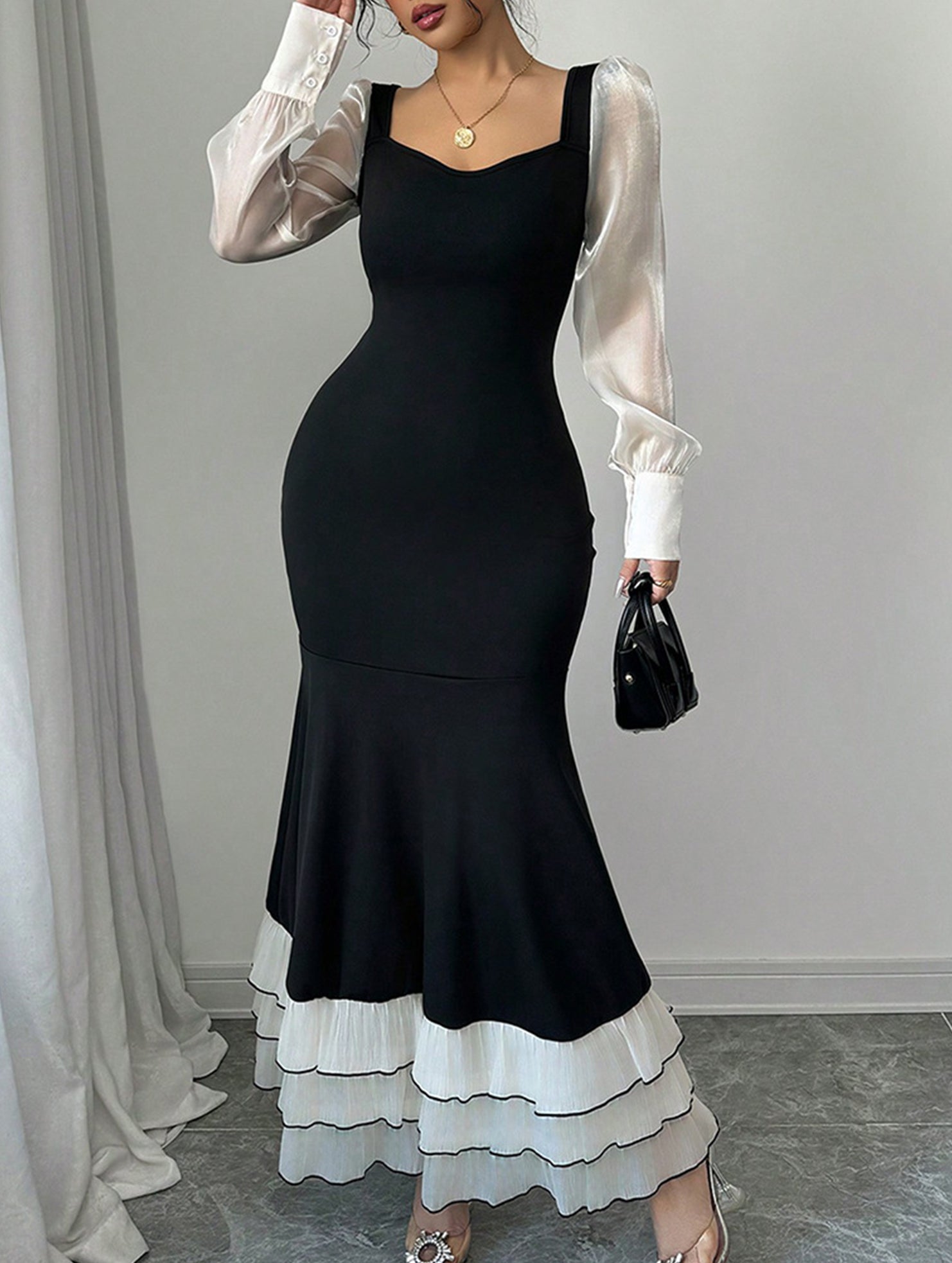 Black colorblock long sleeve mermaid dress with fitted silhouette, stylish design, and elegant neckline.