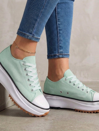 Green women's orthopedic sneakers with lace-up design, providing comfort and support in stylish athletic footwear.