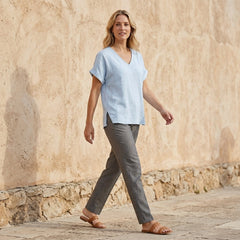 Women’s summer blouse featuring a V-neck and short sleeves, made of denim, styled casually in a lifestyle setting.