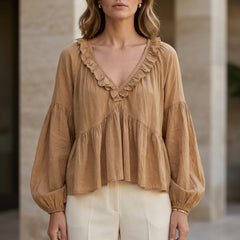 Light brown women's summer blouse with v-neck, long sleeves, and ruffle details, made of denim fabric.