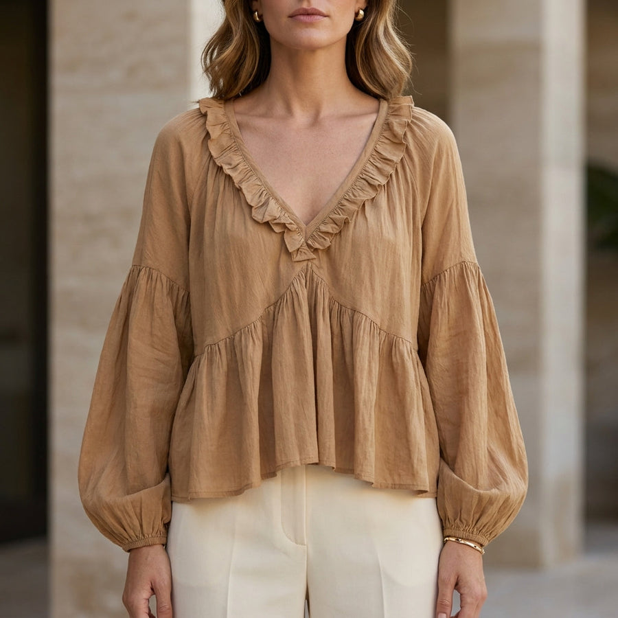 Light brown women's summer blouse with v-neck, long sleeves, and ruffle details, made of denim fabric.