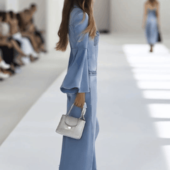 Light blue denim flared long sleeve wide-leg jumpsuit for women, featuring a stylish fitted top and flowing pant legs.