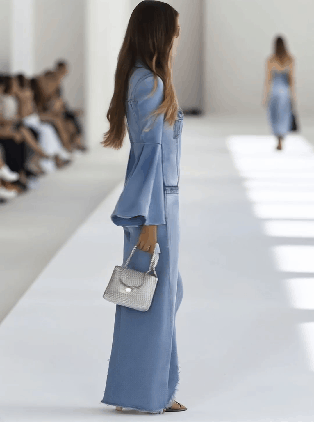 Light blue denim flared long sleeve wide-leg jumpsuit for women, featuring a stylish fitted top and flowing pant legs.