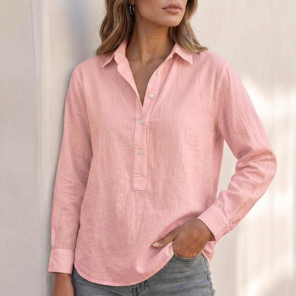 White linen V-neck relaxed-fit women's popover shirt with long sleeves, hanging on a hanger.
