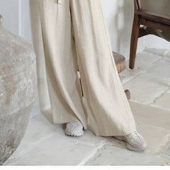 Light beige linen wide-leg trousers for women with a loose pull-on design, relaxed fit, and comfortable style.