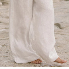 Light beige linen wide-leg trousers for women with a loose pull-on style, featuring a relaxed fit and comfortable waistband.