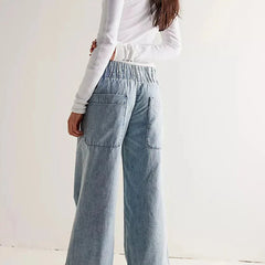 Blue denim wide-leg women's jeans featuring relaxed fit and classic style, shown on a model in a casual setting.