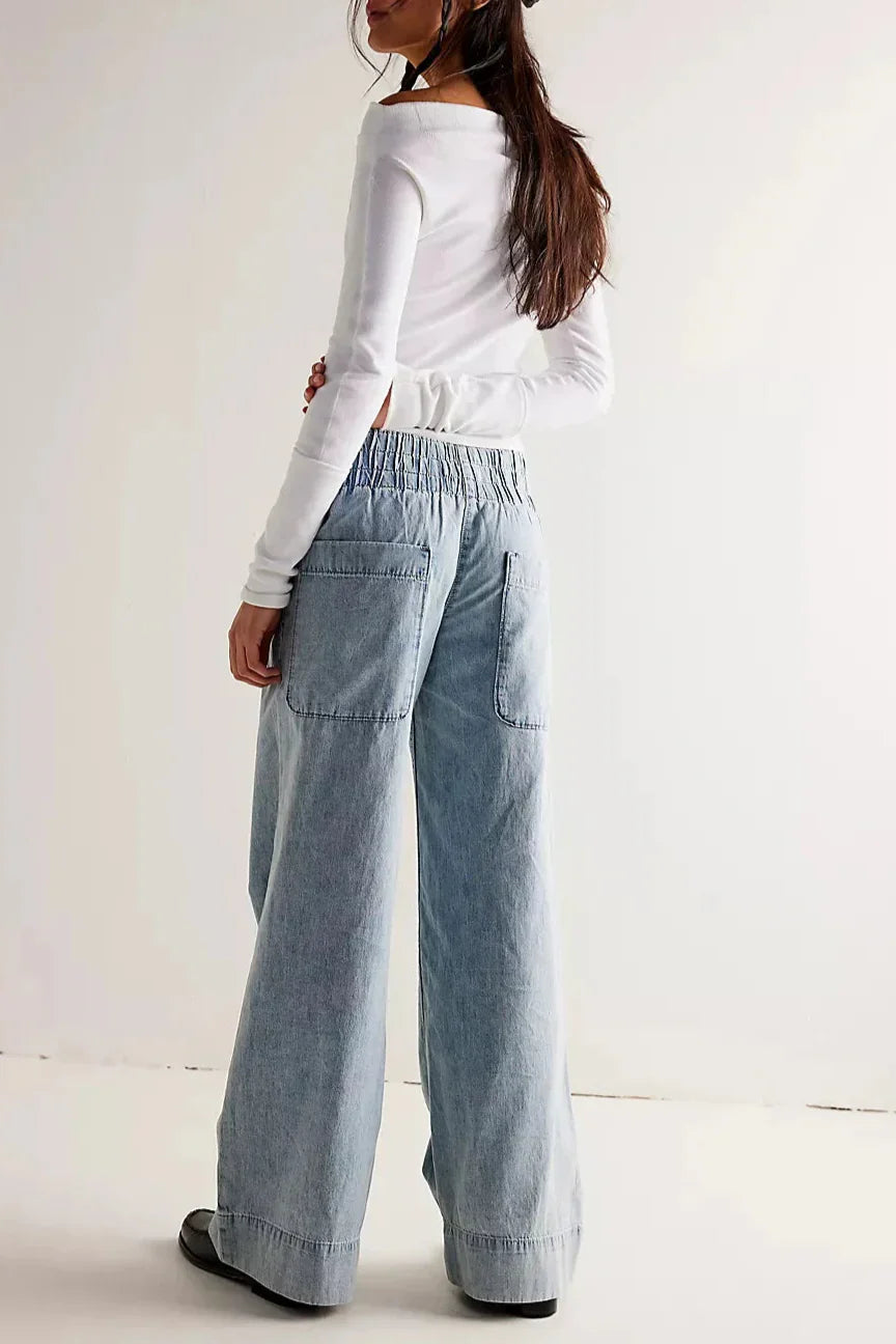 Blue denim wide-leg women's jeans featuring relaxed fit and classic style, shown on a model in a casual setting.