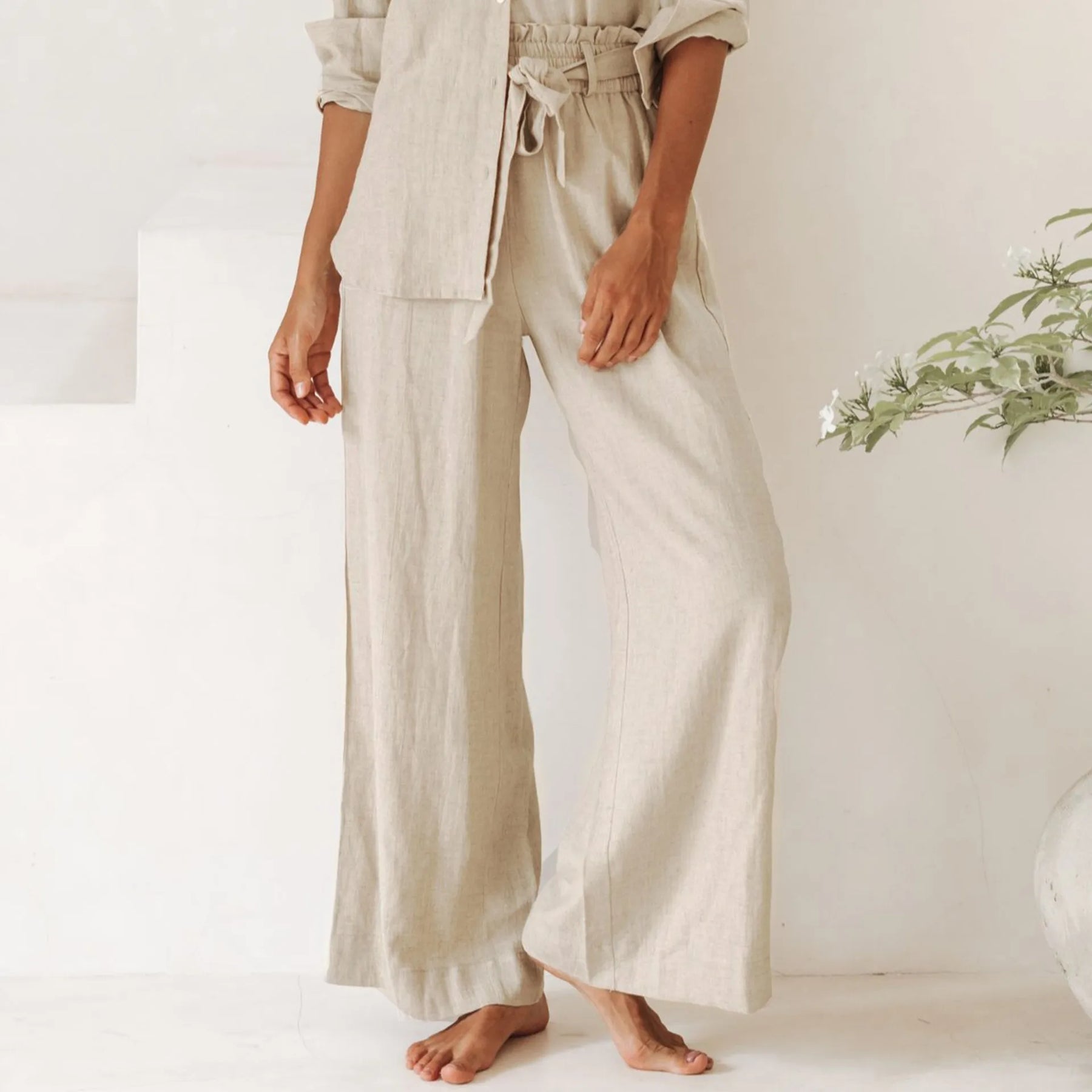 Light beige linen wide-leg trousers for women with a loose pull-on style, featuring a relaxed fit and natural fabric texture.