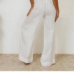 Light beige linen wide-leg women's pants with a loose, pull-on design, styled with a relaxed fit.