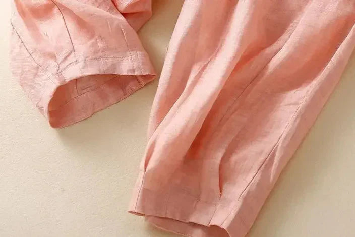 Beige tapered linen women's trousers with a loose, pull-on style, featuring a relaxed fit and comfortable design.