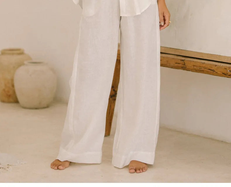 Light beige linen wide-leg women's trousers with a loose fit and pull-on design, displayed on a model.