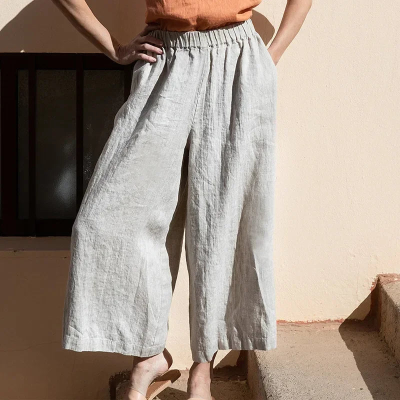 Light beige linen cropped wide-leg women’s trousers with drawstring waist and loose fit, casual pull-on style.
