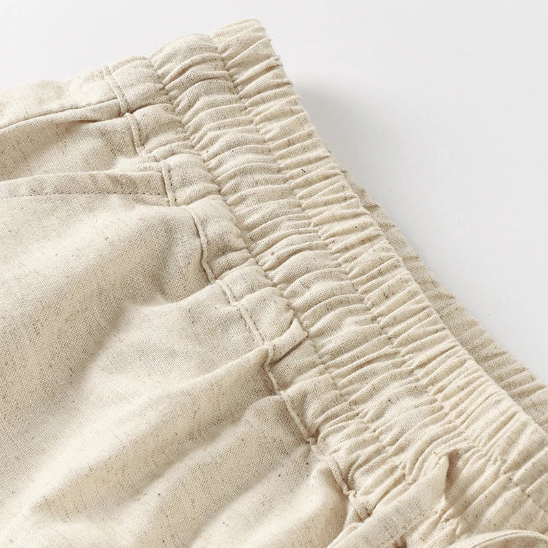 Light beige cotton linen wide-leg women’s trousers with drawstring waist and loose fit, ideal for casual and comfortable wear.
