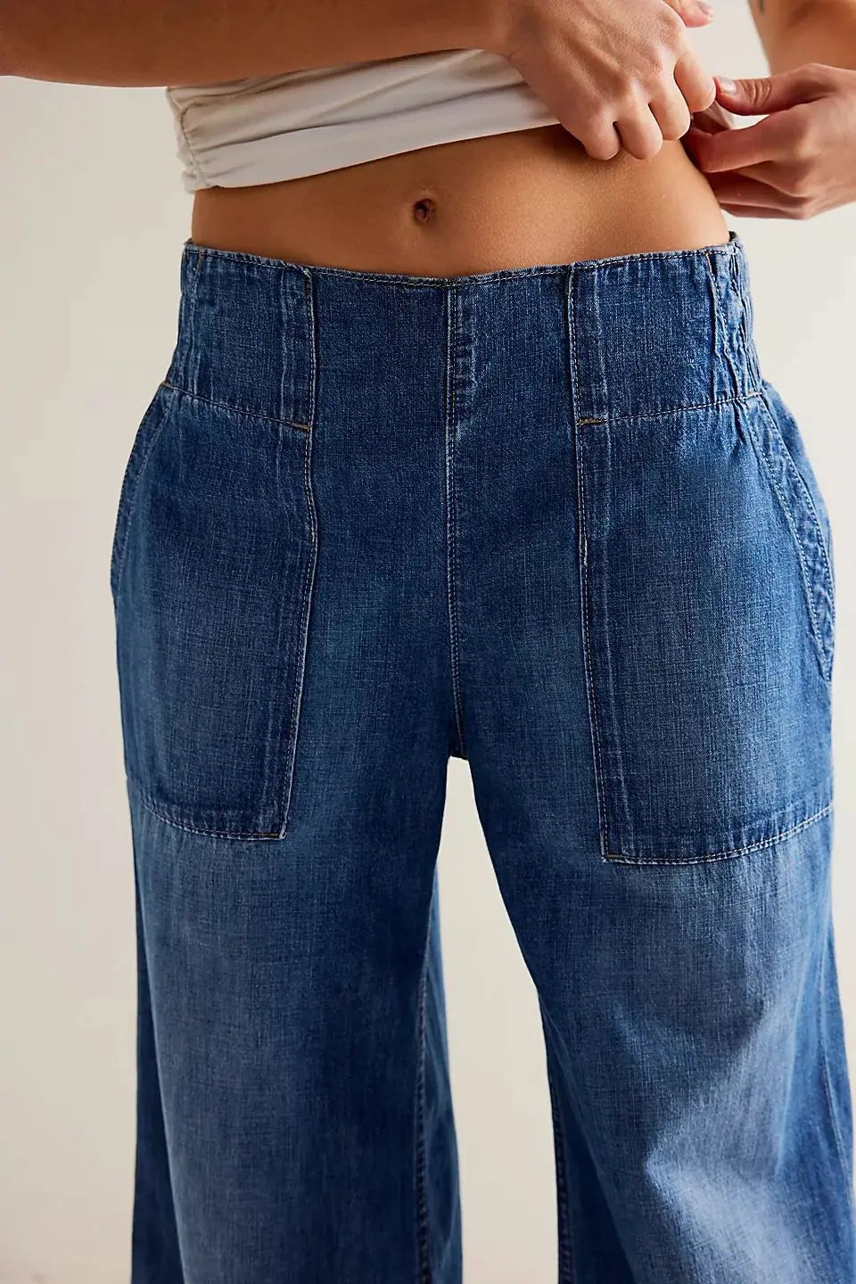 Blue denim wide-leg women's jeans with relaxed fit, featuring classic five-pocket design and stylish high-rise cut.