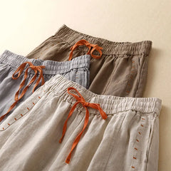 Women's linen wide-leg drawstring trousers with a loose fit, featuring a comfortable pull-on design and relaxed style.