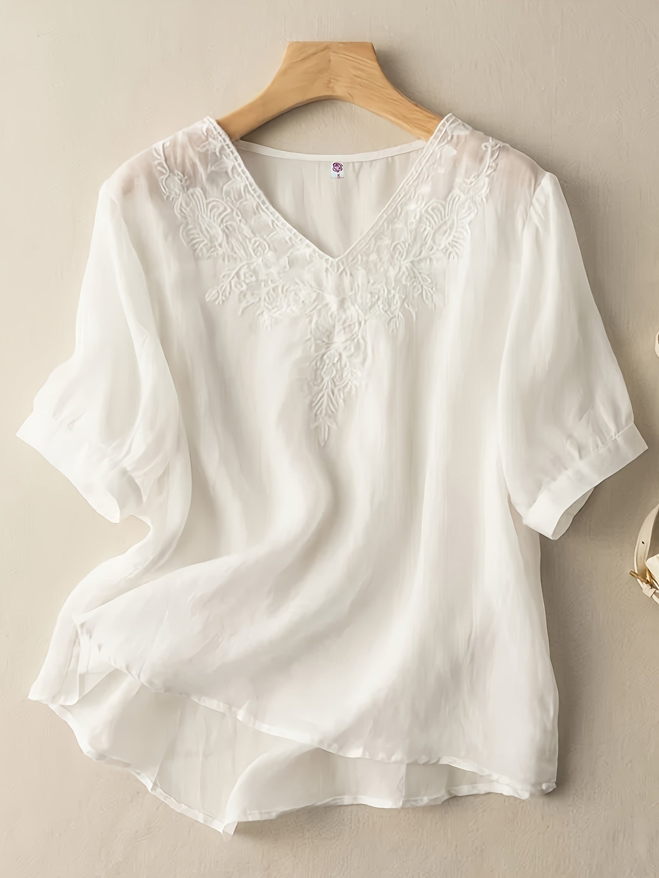 Light beige women's summer blouse with V-neck and flowy linen fabric, casual style perfect for warm weather.