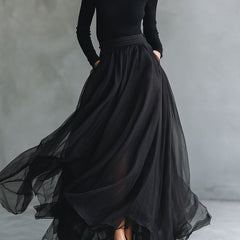 Elegant black tulle maxi dress with patchwork design and fitted knit bodice, flowing and stylish for special occasions.