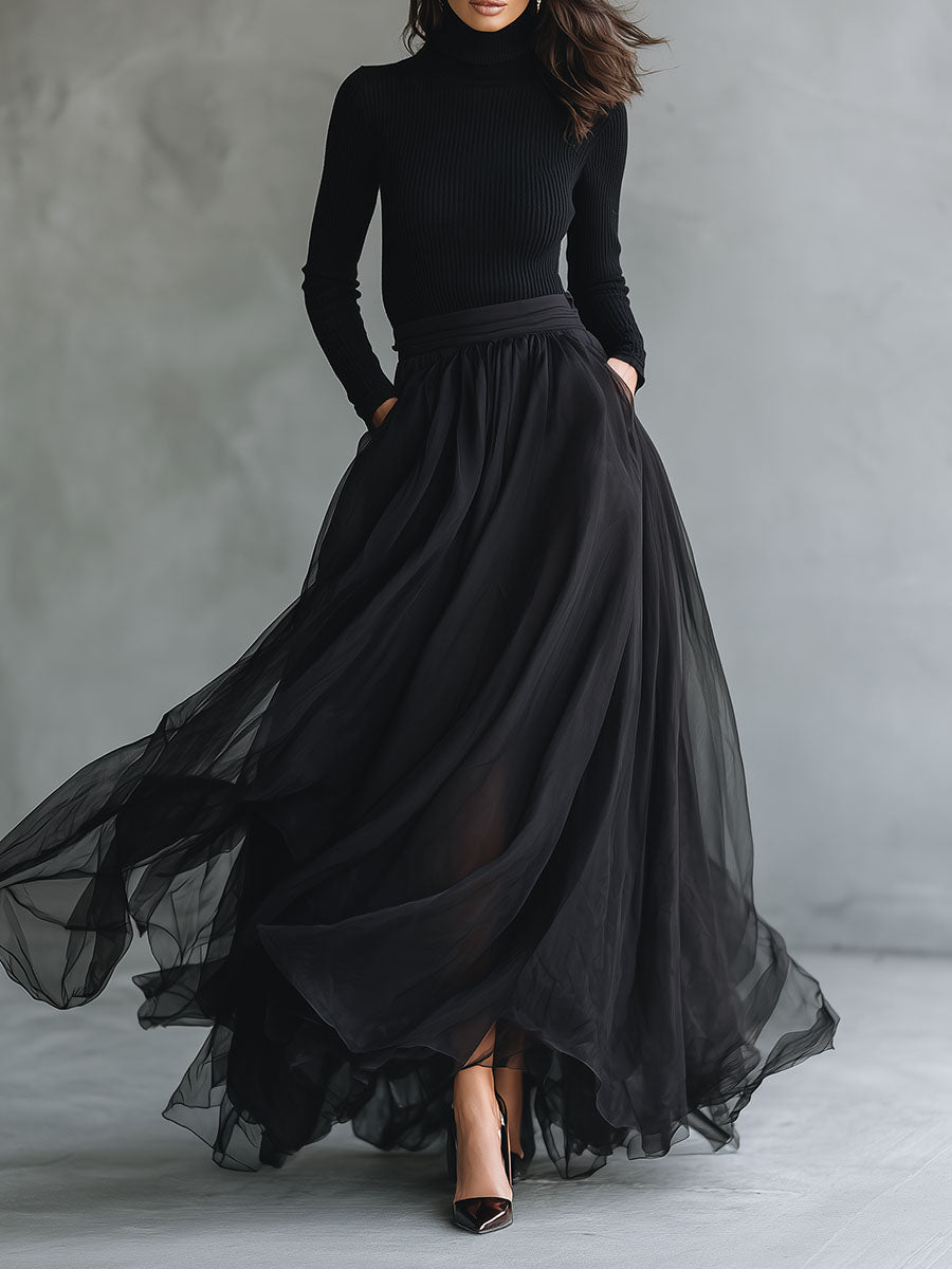 Elegant black tulle maxi dress with patchwork design and fitted knit bodice, flowing and stylish for special occasions.