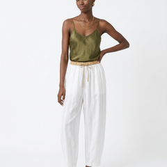 Light beige tapered linen trousers for women, loose pull-on style, shown on a model with a casual outfit.