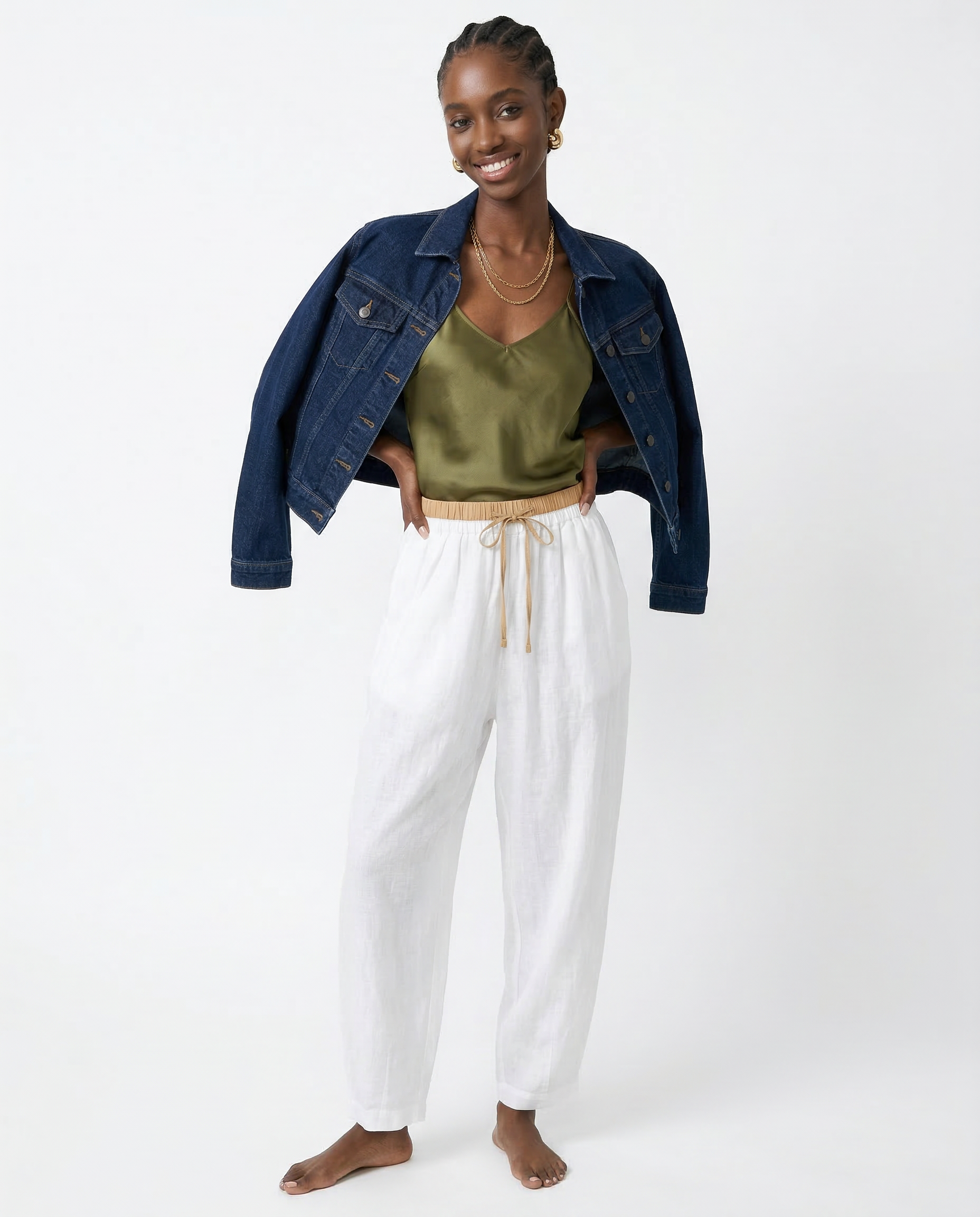 Light beige tapered linen trousers for women with a loose fit and pull-on style, displayed on a model.