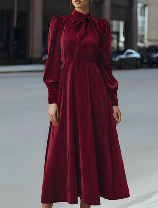 Burgundy velvet pleated bow-neck midi dress by My Store, featuring a stylish cocktail dress design with elegant pleats and a bow neckline.