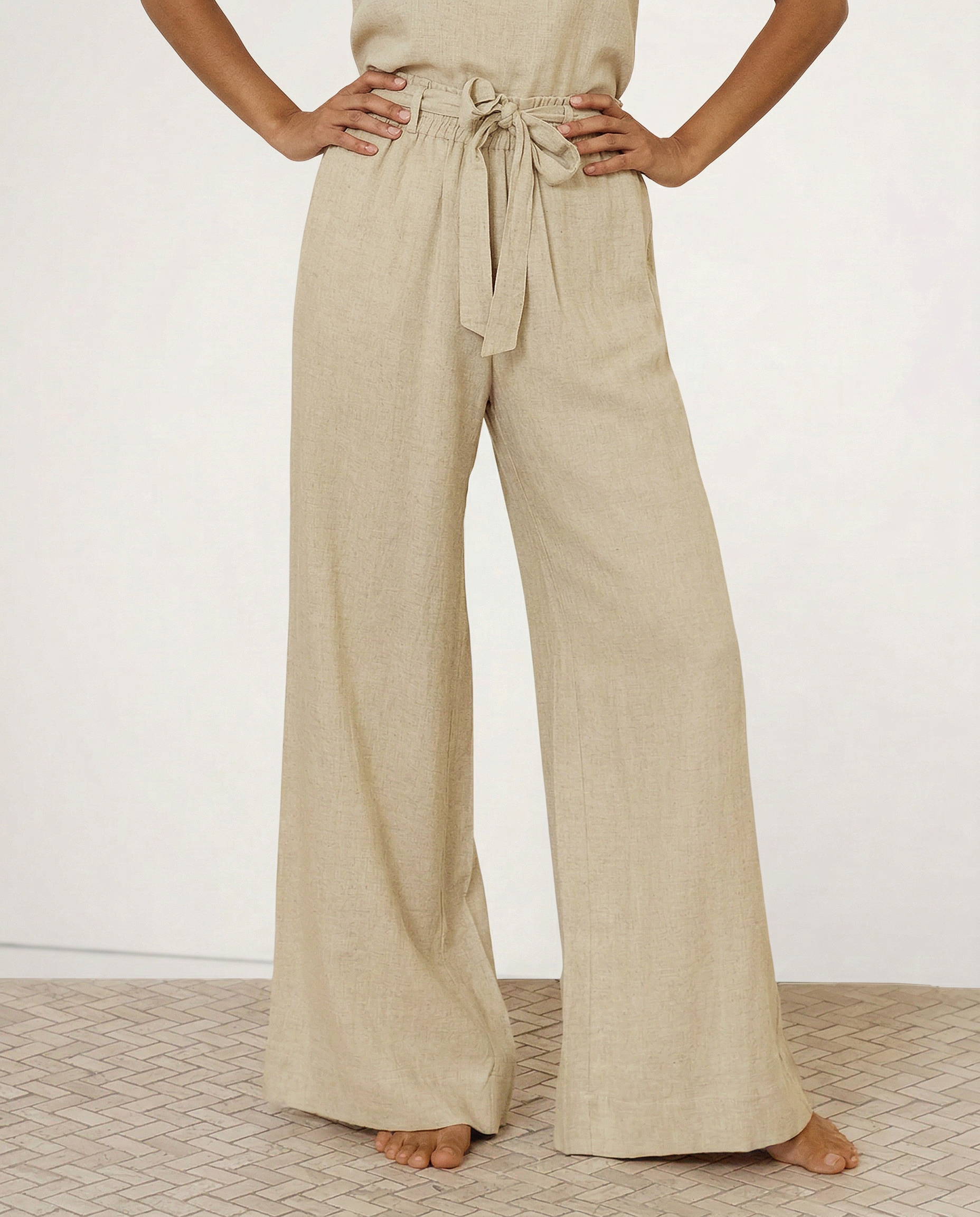Light beige linen wide-leg trousers for women, loose pull-on pants showing soft fabric and relaxed fit.