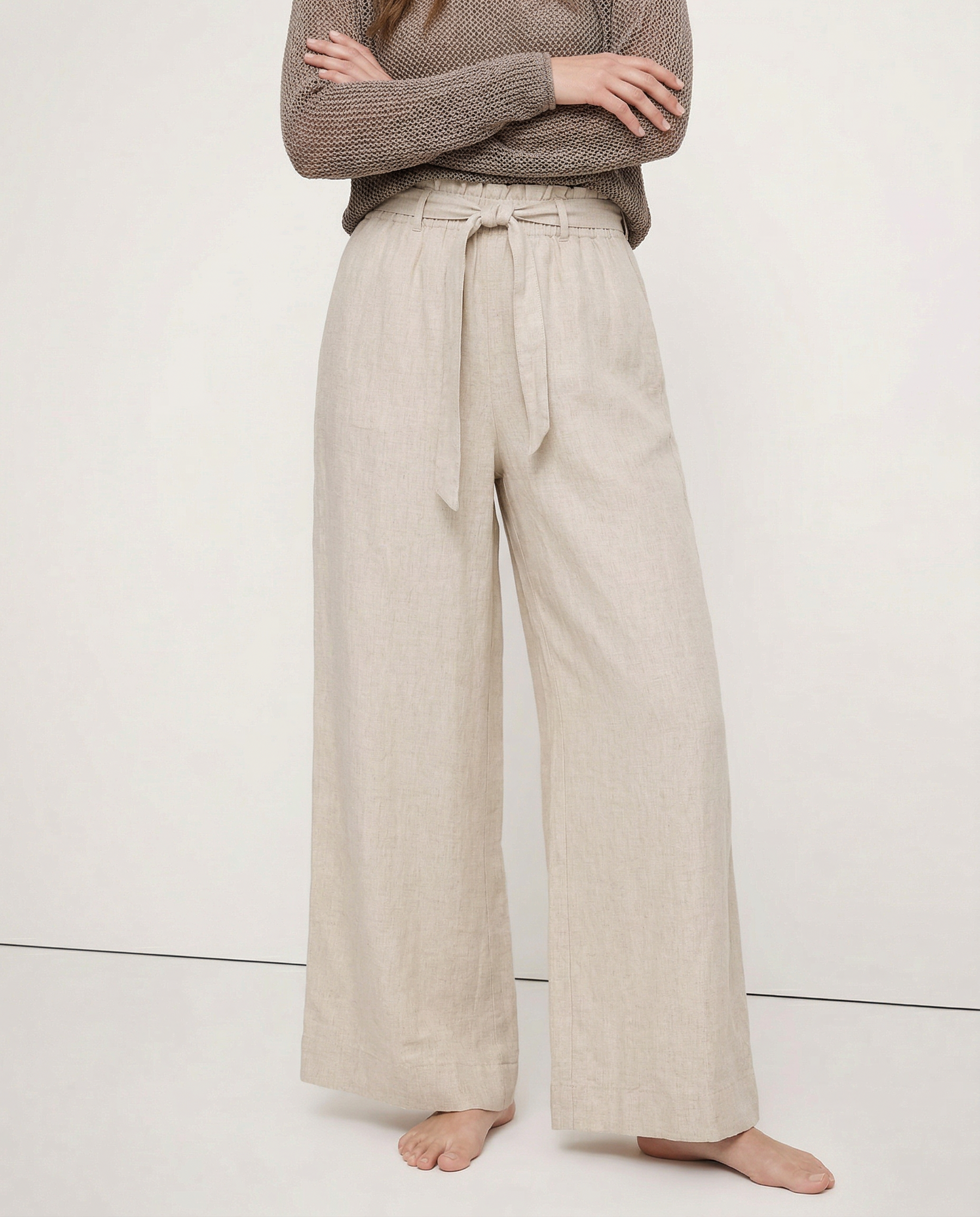 Light beige linen wide-leg trousers for women, loose pull-on pants showing soft fabric and relaxed fit.