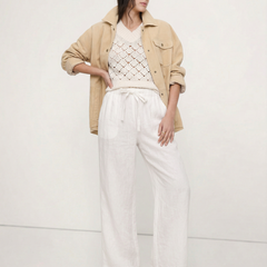 Light beige linen wide-leg women's trousers with a loose, pull-on style and visible high-quality fabric.
