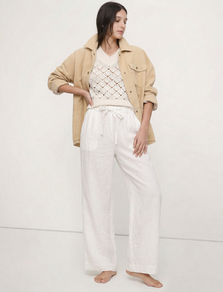 Light beige linen wide-leg women's trousers with a loose, pull-on style and visible high-quality fabric.