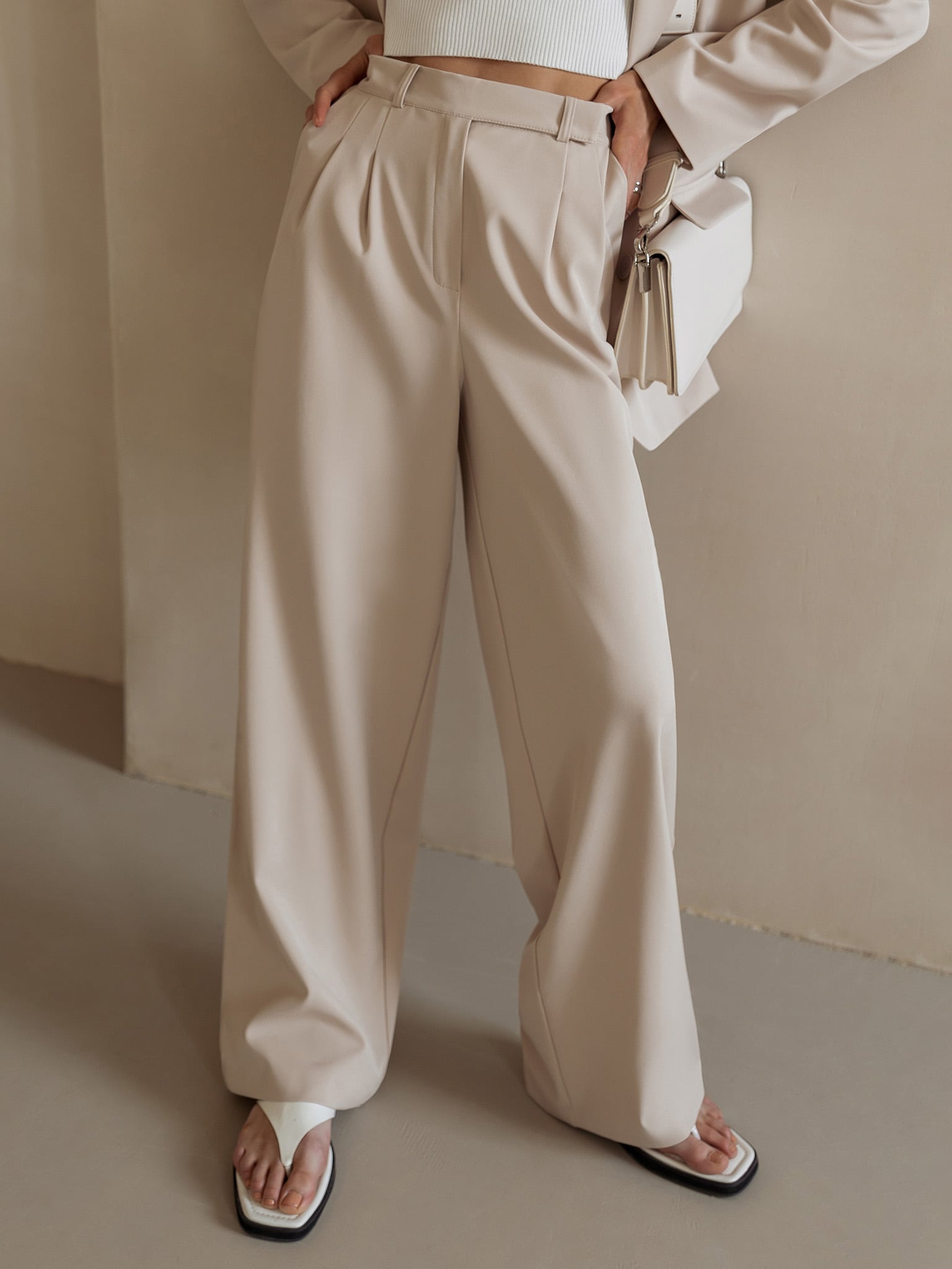 White wide-leg high-waist women's trousers with a relaxed fit, stylish and comfortable for casual or office wear.